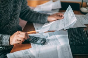 Close-up of male hands with a utility bill, a lot of checks and