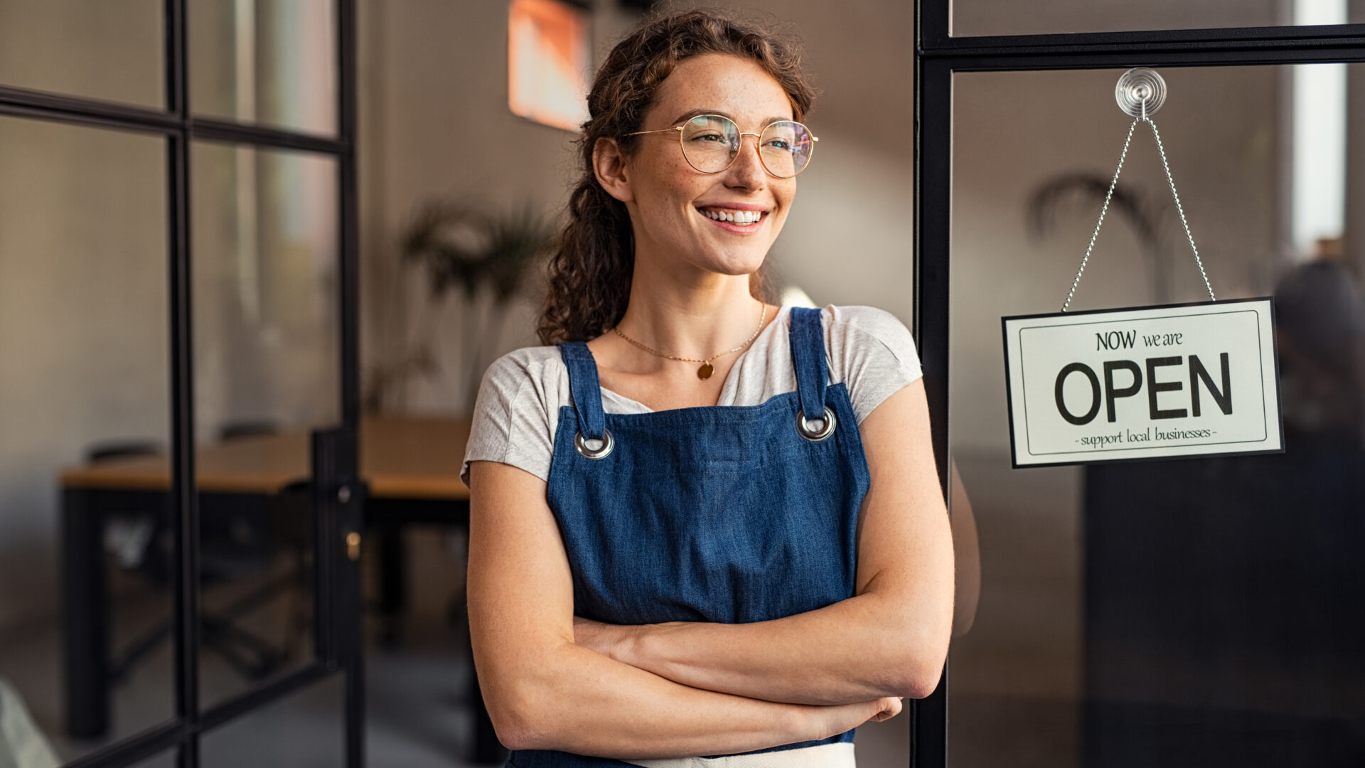 Small business owner standing at cafe entrance