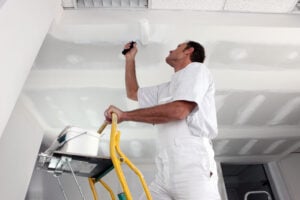 Tradesman painting a ceiling